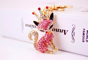 Close-up of pink rhinestone fox keychain with gold metal crown and sparkling stones