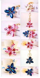 Detail of crystal four-leaf flower keychains in blue and pink with butterfly charms