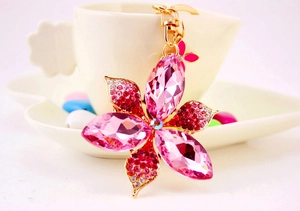 Close-up of pink and red crystal flower keychain with butterfly charm on gold metal