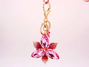 Detailed view of pink crystal rhinestone flower keychain with gold-tone metal base