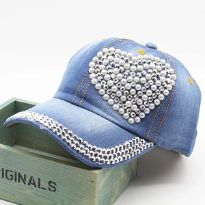 Detail of denim baseball cap featuring pearl heart and rhinestone embellished brim