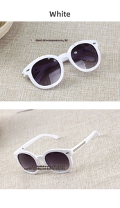 Detailed close-up of white round children sunglasses with UV400 gradient lenses and silver trim