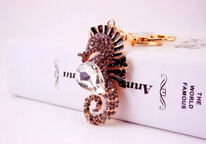 Macro detail of seahorse keychain with black enamel, rhinestones and pear-shaped gemstone