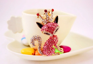 Macro view of crystal fox keychain featuring a pink rhinestone crown and golden finish