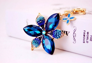 Detail of blue crystal flower keychain with shimmering rhinestones and gold metal finish