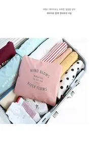 Foldable pink travel organizer bag inside luggage showing neat clothing storage detail