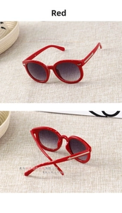 Detail of red round frame kids sunglasses featuring gold arrow accents on the temples