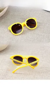 Detail view of round yellow frame kids sunglasses with metal arrow accents and UV400 lenses