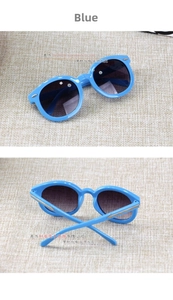 Detail view of round blue kids sunglasses showing golden arrow metal accents on the frame