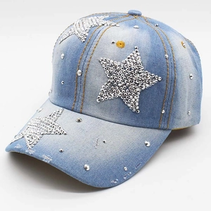 Detail van blauwe gewassen denim baseballpet met ster-strass en versleten randdetails