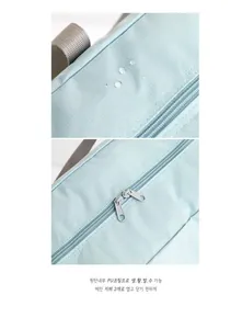 Detail showing waterproof fabric with water drops and dual zippers on the travel bag