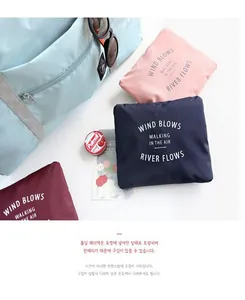 Folded portable waterproof travel bags in navy, pink, and burgundy colors