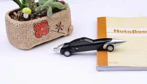 Detailed close-up of a creative car-shaped ballpoint pen in black and silver finishes