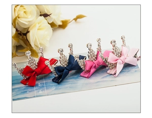 Detail view of four ribbon bow hair clips with crystal crowns in diverse colors