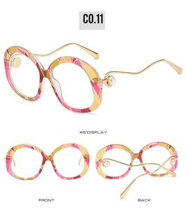 Detail view of oval sunglasses with pink mosaic frames and gold wavy faux pearl temples