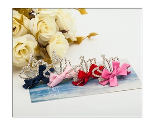 Detail of four colorful ribbon bow hair clips with crystal crown accents for children