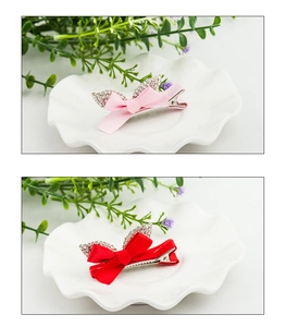 Close-up of pink and red bow hair clips with crystal rhinestones on white plate