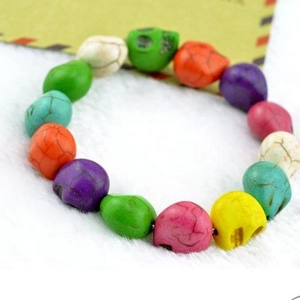 Detailed macro view of colorful skull-shaped synthetic turquoise beads on a stretch bracelet