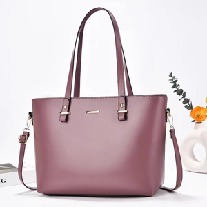 Detail of elegant purple leather tote bag with gold hardware and removable shoulder strap