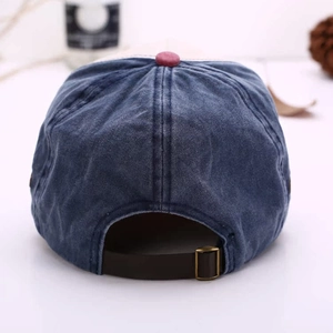 Detail view of washed denim baseball cap back with brown leather strap and metal buckle