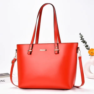 Close-up of red tote bag with gold metal hardware and detachable long shoulder strap