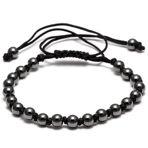 Close-up of black bead bracelet with polished hematite stones and adjustable woven cord