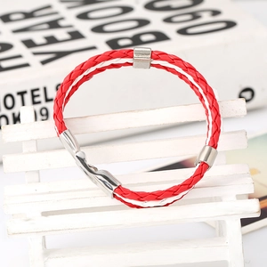 Close-up of red and white braided leather bracelet with silver metal clasp on mini bench
