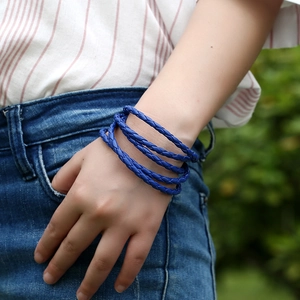 Detailed view of multilayer braided blue leather bracelet on wrist for casual style