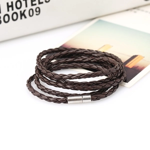 Macro detail of dark brown multilayer braided leather bracelet with silver magnetic clasp