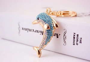 Macro shot of sparkling blue rhinestones on a golden metal dolphin keychain accessory