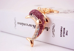 Detail of dolphin keychain with purple and white crystals on a gold-plated lobster clasp