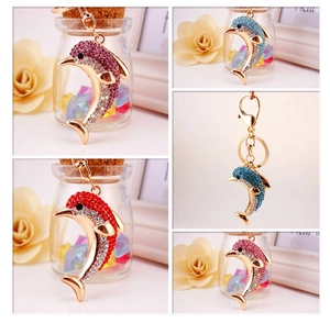 Detailed close-up of rhinestone dolphin keychains in multiple colors with gold finish