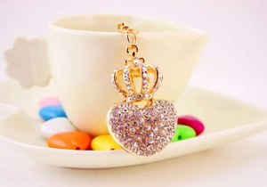 Macro shot of gold heart keychain with crown detail and embedded crystal accents
