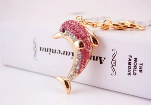 Macro shot of gold dolphin keychain with sparkling pink and clear rhinestones detail