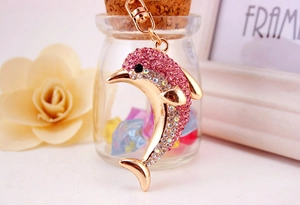 Close-up of pink rhinestone dolphin keychain with gold metal plating and lobster clasp