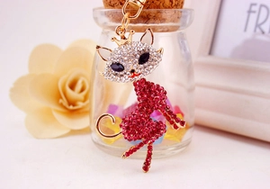 Macro shot of crown cat keychain with pink and white rhinestones on golden metal