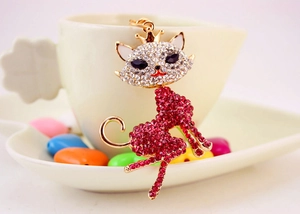 Close-up of a sparkling cat keychain with red and clear rhinestones and golden crown