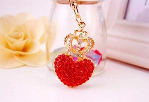 Detail of a sparkling gold crown and red heart keychain encrusted with crystal rhinestones