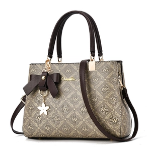Sac à main Oumifei avec motif monogramme et pendentif floral en café beige