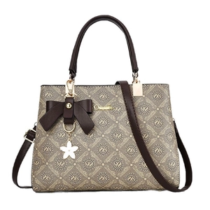 Sac à main marron élégant avec grand nœud et pendentif floral sur fond blanc pur