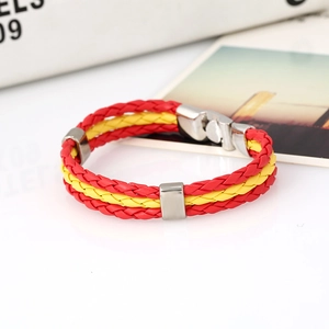 Macro detail of red and yellow braided leather bracelet with a polished silver metal clasp