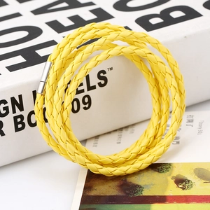 Detail of multi-layer bright yellow braided PU leather bracelet with silver magnetic clasp