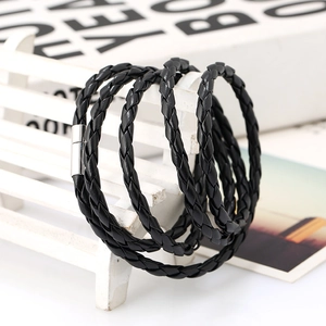 Macro detail of multilayer braided black leather bracelet with silver magnetic buckle