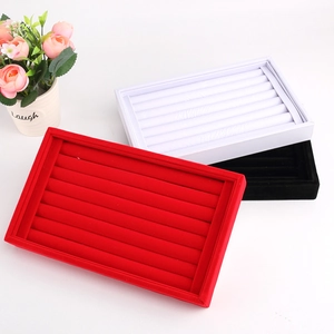 Detail of red, white, and black velvet jewelry trays with multiple storage slots
