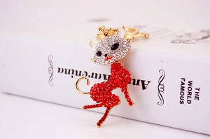 Detailed close-up of a fox-shaped keychain encrusted with sparkling red and white rhinestones