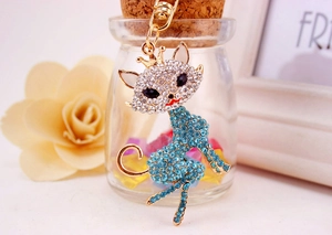 Detailed close-up of a golden cat keychain with blue and clear sparkling rhinestones