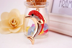 Close-up of golden dolphin keychain with red and clear rhinestones on a table