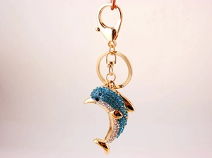 Detailed view of the dolphin keychain with blue crystals and golden metal ring
