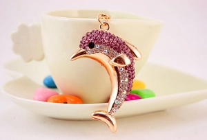 Close-up of rose gold dolphin keychain featuring purple crystal rhinestones and metal details