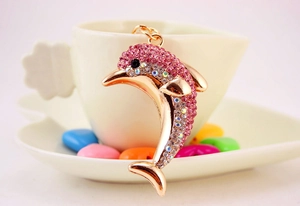 Close-up of sparkling pink rhinestone dolphin keychain in rose gold plating detail